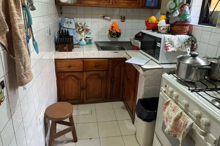 Cocina original antes de la ampliación: espacio mínimo con muebles de madera antiguos
