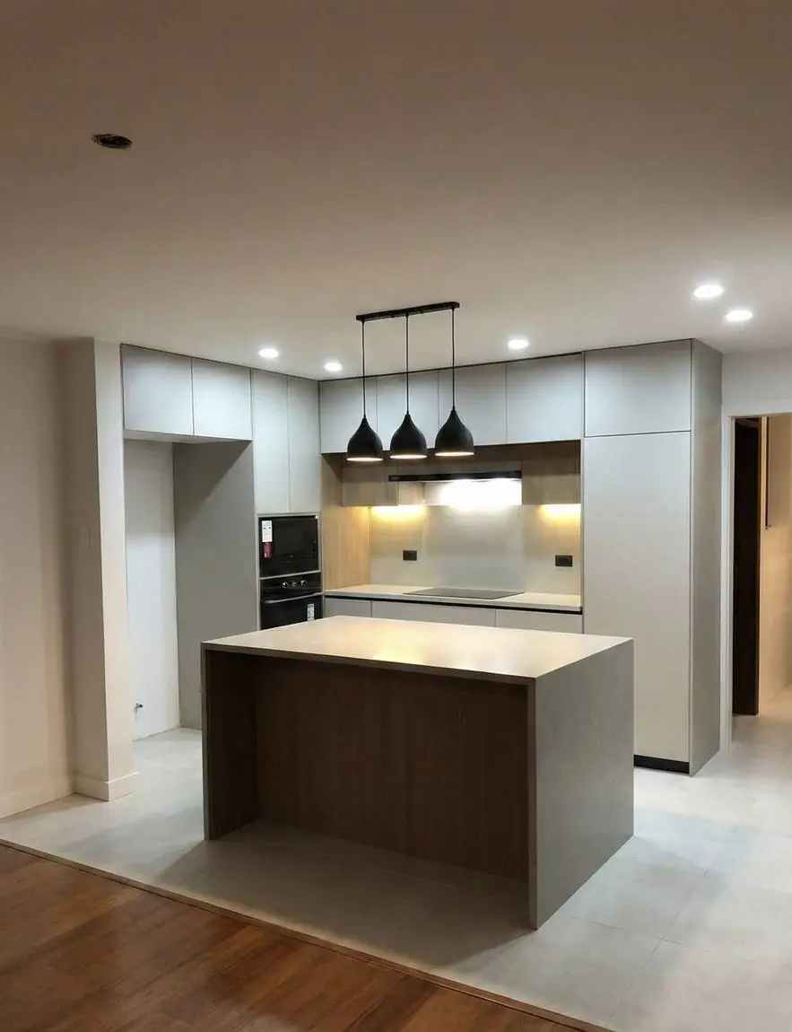 Cocina terminada con isla, horno empotrado y luz bajo los muebles altos