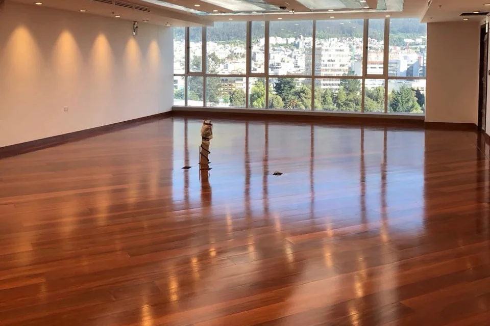 Oficina rehabilitada con piso de chanul lacado y ventanales con vista a Quito