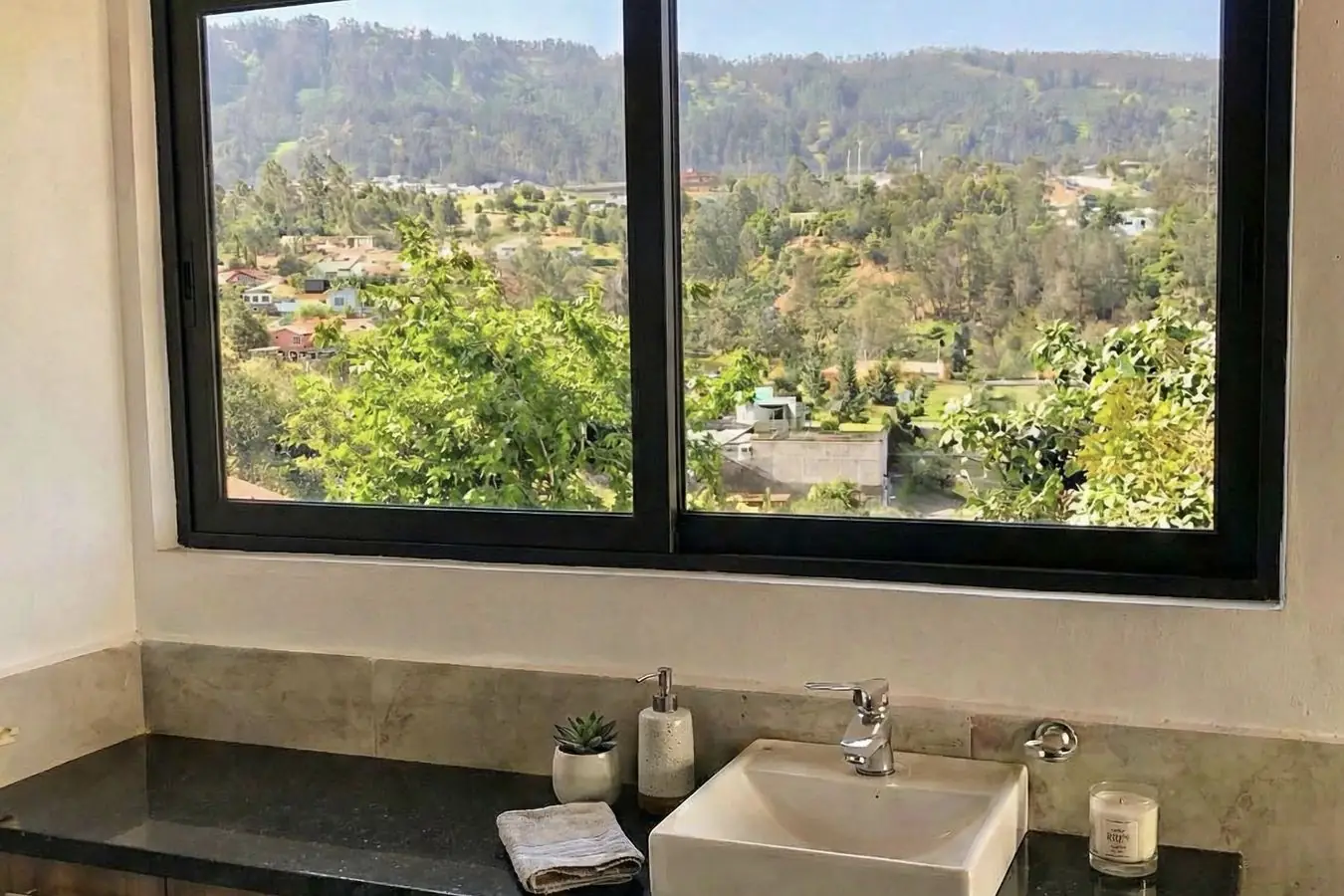 Baño terminado con mesón de granito y ventana con vista a las montañas