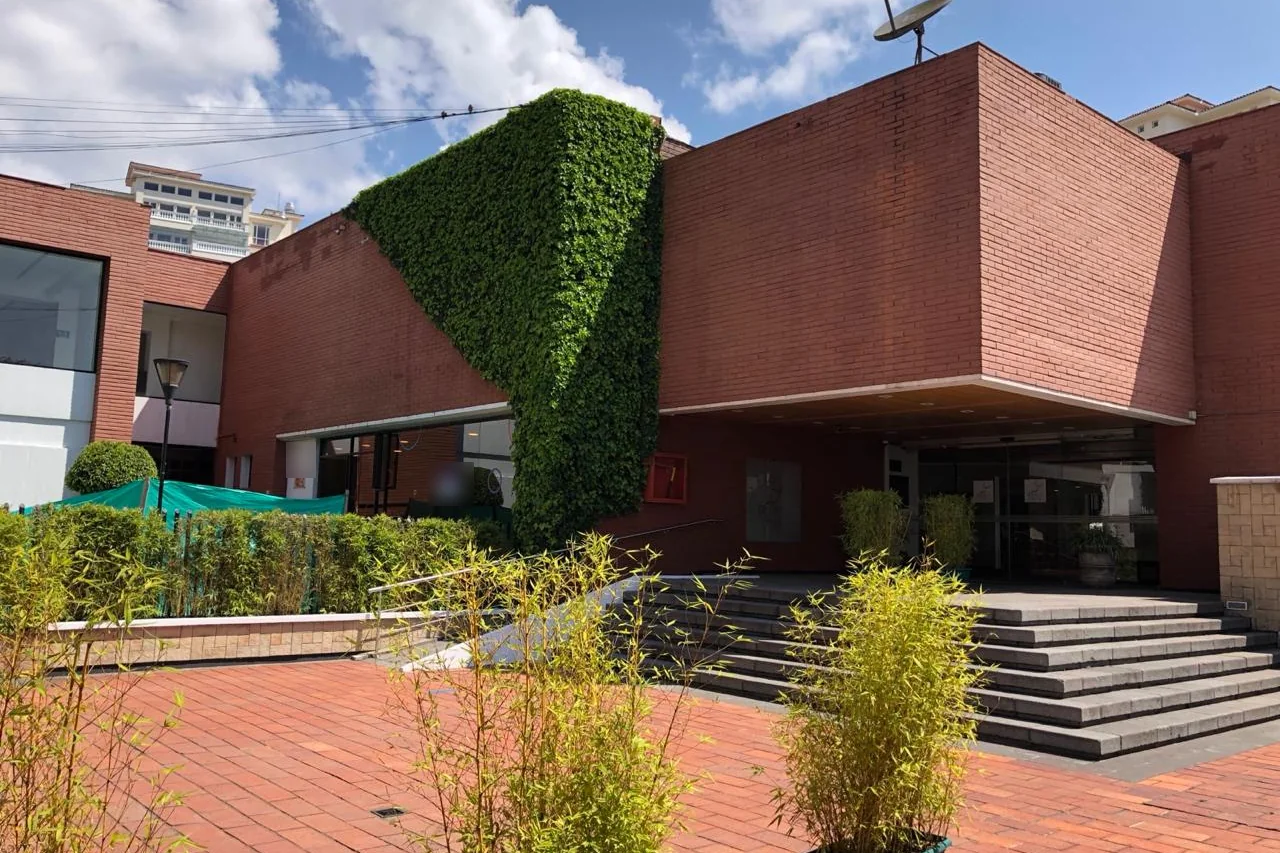 Ingreso del Club de Tenis Buena Vista en Quito Tenis, fachada de ladrillo con muro verde y graderío de acceso