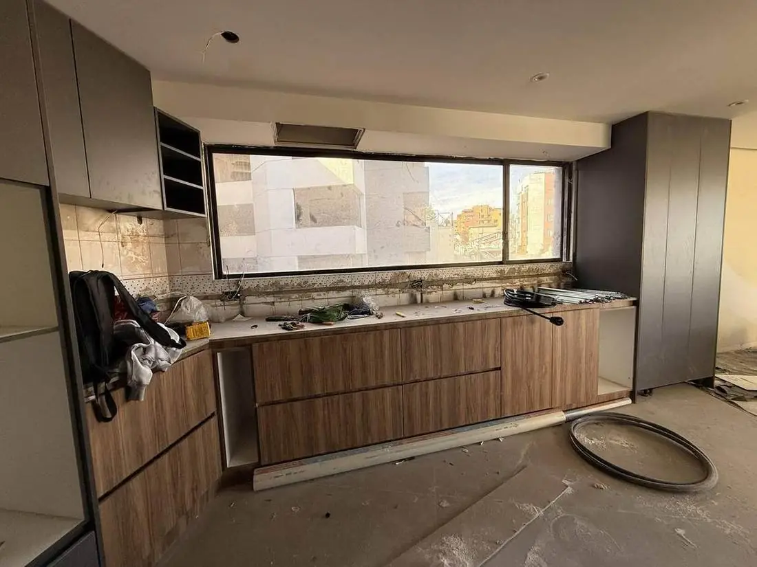 Quito Tennis, cocina con muebles bajos en madera bajo el ventanal