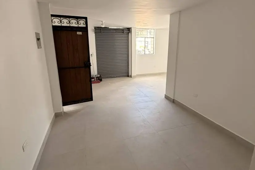 Local comercial terminado en San Carlos, Quito: piso de porcelanato, paredes blancas y puerta enrollable